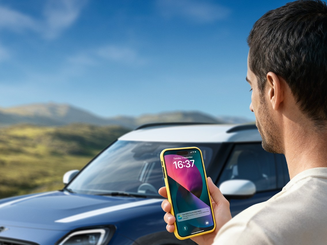 A man sitting in a MINI looking at his phone